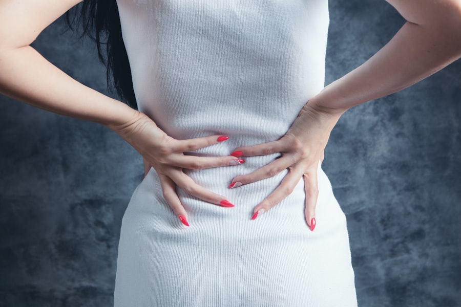 A woman holding her lower back in discomfort